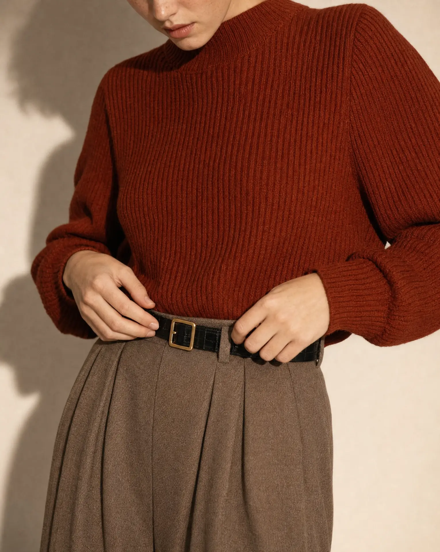Belt and waistband detail with rust ribbed knit and pleated wool skirt